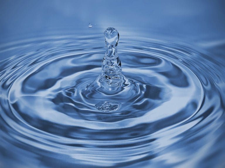 A single water droplet falling and rippling to help illustrate why dripping a faucet keeps pipes from freezing