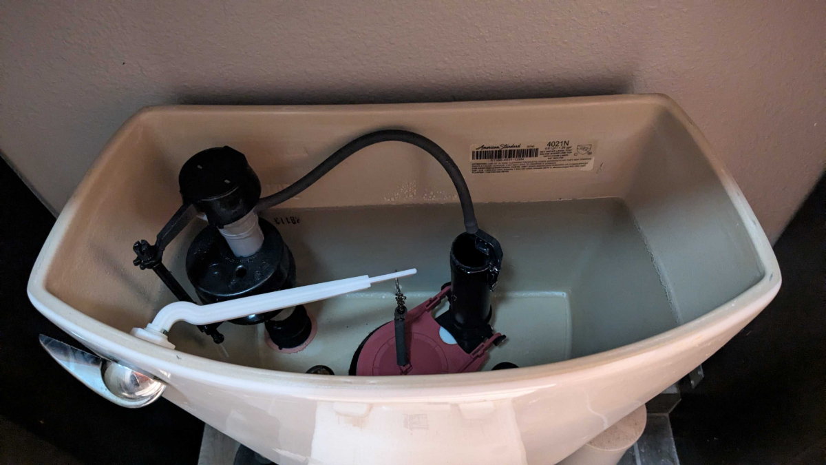 A look inside of a toilet with the lid off.