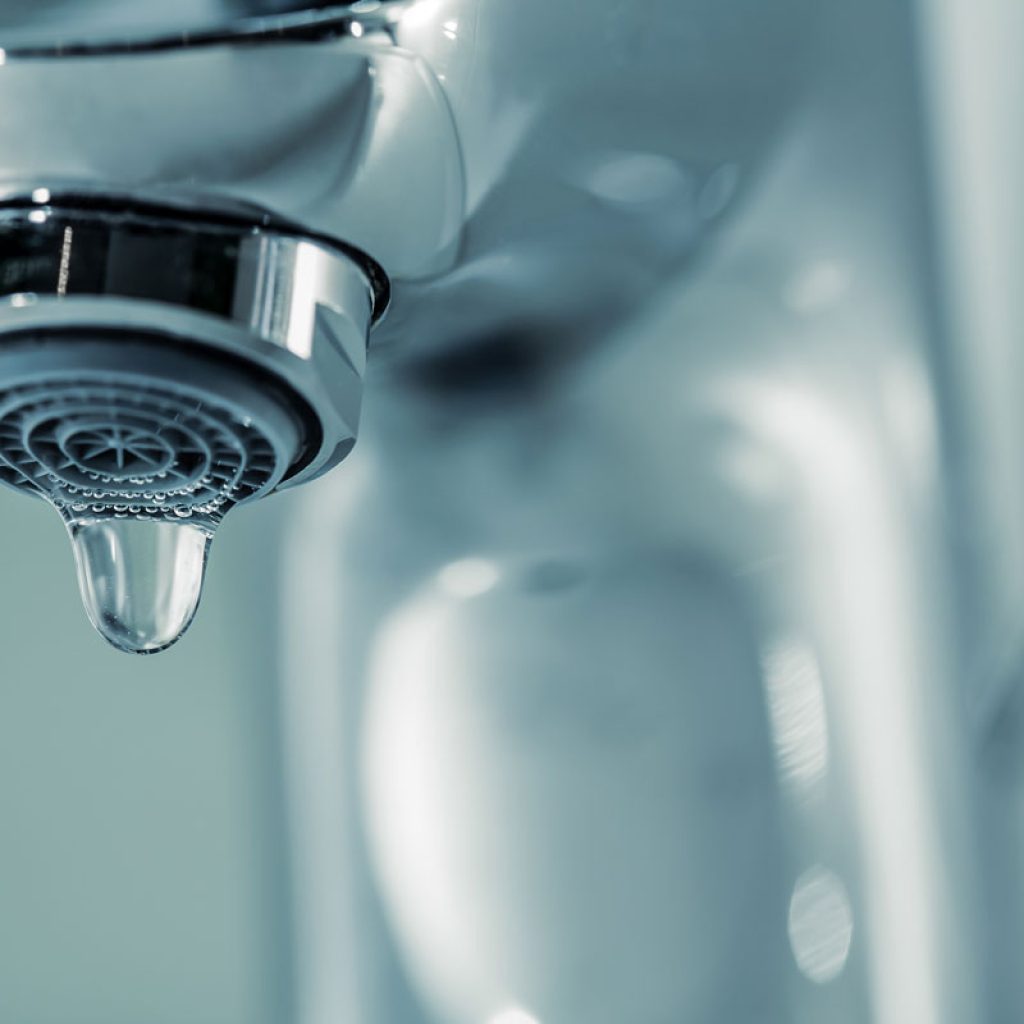 A single drop coming from a bathroom faucet to help illustrate a leaking faucet and Reasons for Low Water Pressure and leak repair