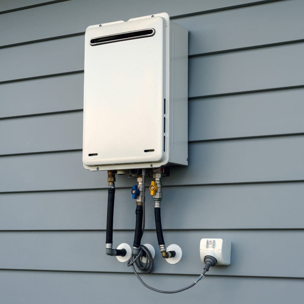 Modern external continuous flow gas water heater mounted on house wall to help illustrate Tankless Water Heater: Gas vs Electric and innovations in plumbing